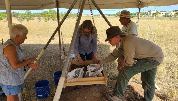 people sifting through dirt looking for artifacts