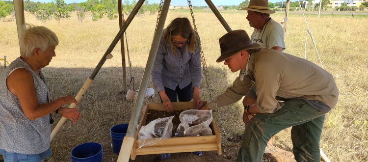 people sifting through dirt looking for artifacts